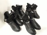 five pairs of black boots with bows on them on a white surface