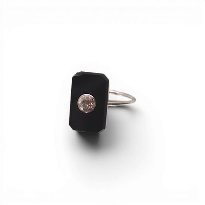 une image représentant une bague ornée d'une pierre noire et d'un diamant blanc