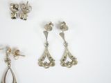 two pairs of silver earrings and a pair of silver earrings