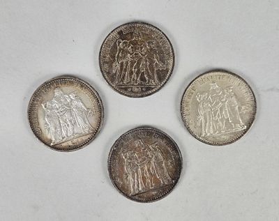 four different types of silver coins on a white surface