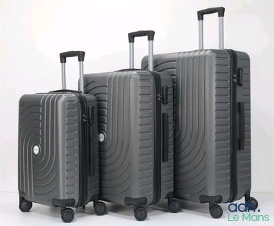 trois bagages empilés les uns sur les autres sur une surface blanche
