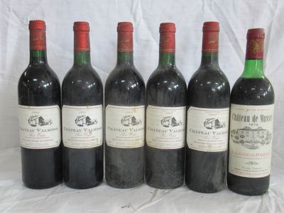six bouteilles de vin sont alignées sur une table