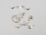 a lot of different rings and earrings on a white surface
