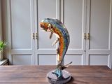 a statue of a fish that is on a wooden table