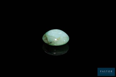 un gros plan d'une pierre de jade verte sur une surface noire