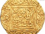 a close up of a gold coin with arabic writing on it