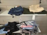 several pairs of jeans are on a shelf in a clothing store