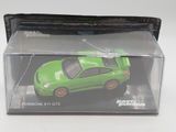 a green toy car in a clear box on a white surface