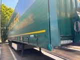 un grand camion vert garé sur un parking