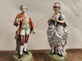 deux figurines représentant un homme et une femme posées sur une table en bois