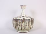 a white and brown vase sitting on a white surface