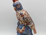 une figurine représentant un oiseau perché sur un rocher