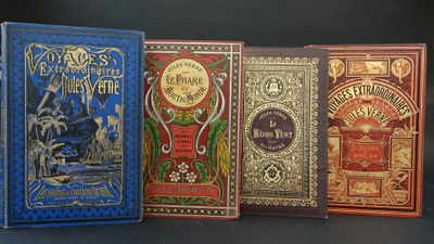 quatre livres sont alignés sur une table