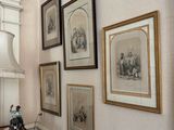 a picture of a hallway with a lamp and pictures on the wall