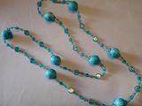 un long collier bleu orné de perles