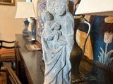 une statue de femme tenant un enfant sur une table