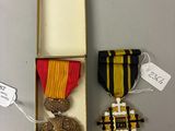 deux médailles et une médaille se trouvent dans une boîte posée sur une table