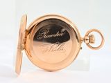 an image of a close up of a pocket watch on a white surface