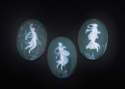 trois camées verts et blancs représentant des personnages, sur fond noir