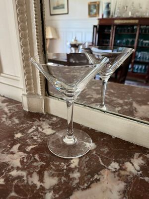 two martini glasses sitting on a table in front of a mirror