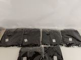 four bags of black plastic bags sitting on top of a table