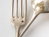 a silver fork and a silver spoon on a white table
