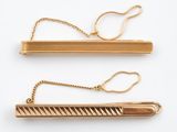deux paires de barrettes plaquées or sur fond blanc