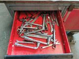 many wrenches in a red toolbox on the floor