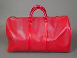 a red duffel bag sitting on top of a table