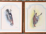 two paintings of birds hanging on a wall in a room
