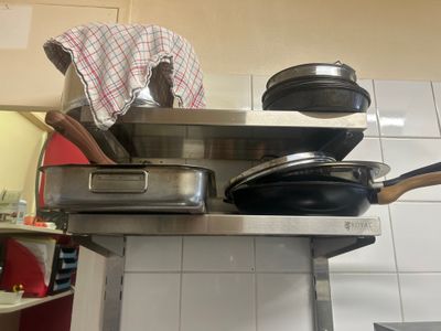 pots and pans are stacked on top of a kitchen counter
