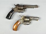 deux revolvers posés sur une surface blanche