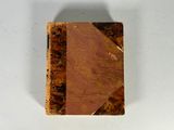 un petit livre à la couverture marron posé sur une table