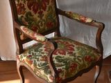 a chair with a floral upholstered seat on a tile floor