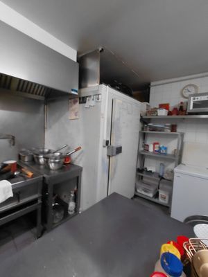 une cuisine équipée d'une cuisinière, d'un évier, d'un réfrigérateur et d'autres appareils électroménagers