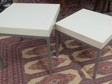 two tables that are sitting on a rug on the floor