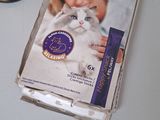 a cat sitting on a table next to a package of catnip