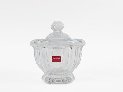clear glass jar with a lid and a red label on it