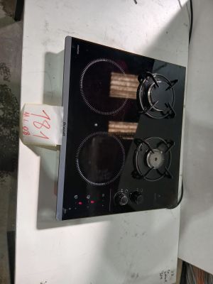 une cuisinière noire équipée de deux feux, avec un rouleau de papier toilette posé à côté de la cuisinière