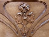 a close up of a wooden cabinet with a flower design on it