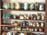 une étagère sur laquelle sont disposées de nombreuses tasses de toutes sortes