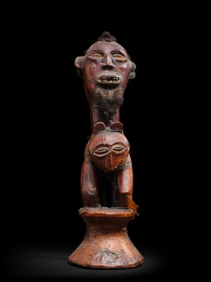 une statue en bois représentant un homme tenant un bébé dans ses bras