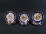 three blue and gold plates with a picture of a man and woman on them
