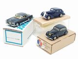 three toy cars sitting on top of a cardboard box