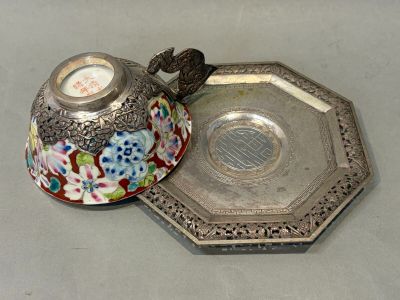 a silver plate with a silver lid and a silver plate with a flower design on it