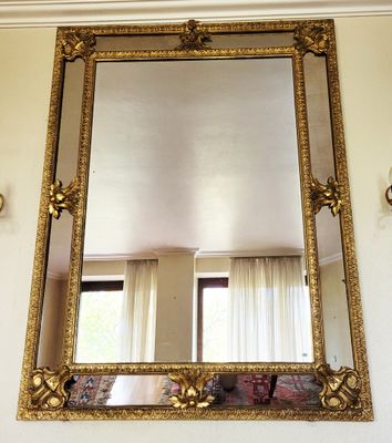 un miroir accroché au mur au-dessus de la cheminée du salon