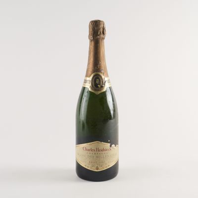 la bouteille de champagne est posée sur une surface blanche