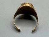an image of a gold ring on a white surface