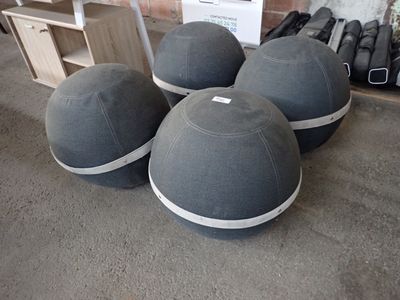 trois boules grises posées sur le sol, à côté d'une étagère en bois