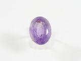 Gros plan sur une bague ornée d'une pierre violette
